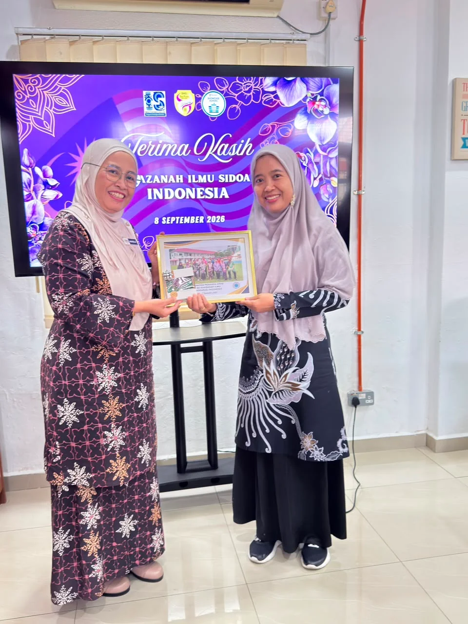 Penyerahan kenang-kenangan dengan layar ucapan terima kasih untuk Khazanah Ilmu Sidoarjo Indonesia.